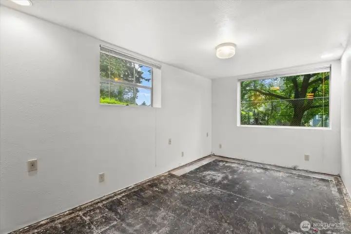 Bright room with large windows overlooking the yard and mature trees, bringing in natural light throughout the day.