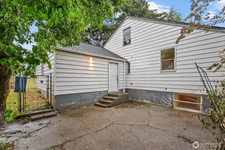 Rear exterior featuring a patio area, fenced access, and convenient entry into the home.