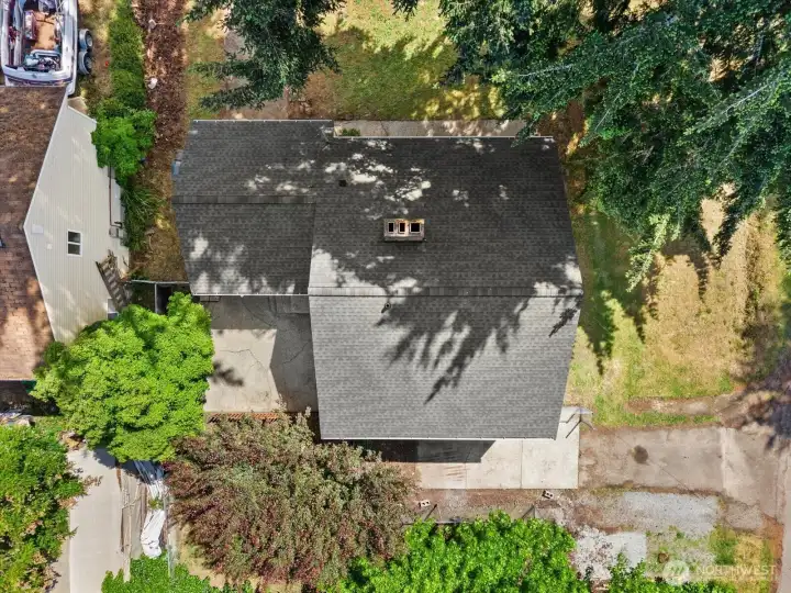From above, you can appreciate the footprint of the home, the mature tree canopy, and the space surrounding the property.