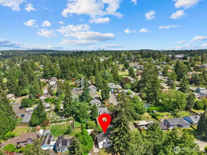 A bird's-eye view highlights the home's position within the neighborhood, surrounded by greenery and close to local conveniences, shopping, dining, and commuter routes.