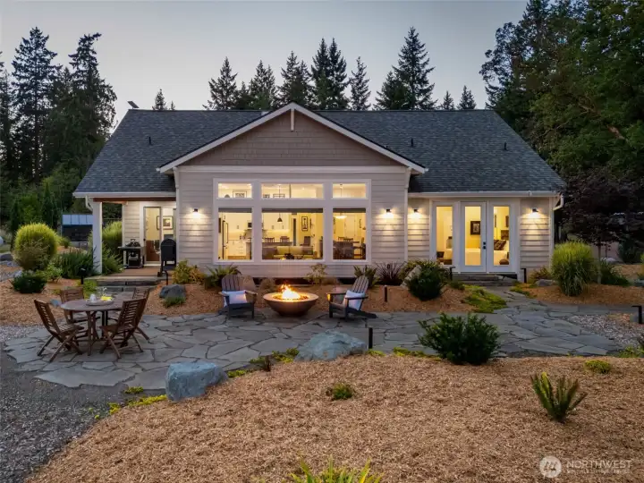 The waterfront side of the home featuring inviting outdoor spaces. The waterfront side of the home featuring inviting outdoor spaces.