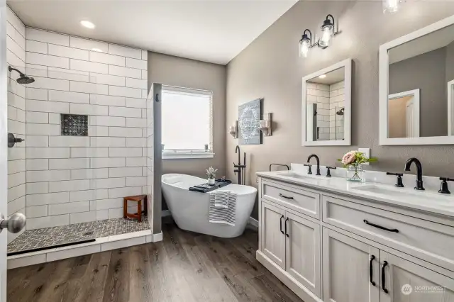 The updated ensuite oasis features a gorgeous tile shower, freestanding soaking tub, and a double vanity for ultimate comfort and style.
