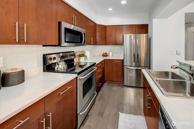 Bright kitchen is beautifully updated with Quartz counters, designer tile backsplash, high-end stainless appliances & breakfast bar for additional eat in or entertaining space!