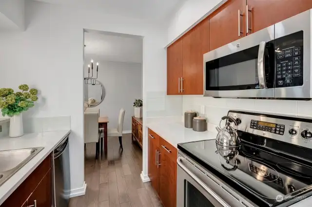 Bright kitchen is beautifully updated with Quartz counters, designer tile backsplash, high-end stainless appliances & breakfast bar for additional eat in or entertaining space!