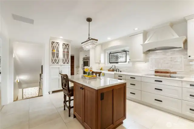 A built-in hutch, tons of high-end cabinetry, stone backsplash, wood vent hood and farm sink & faucet are just a few of the quality features that add beauty to this functional space
