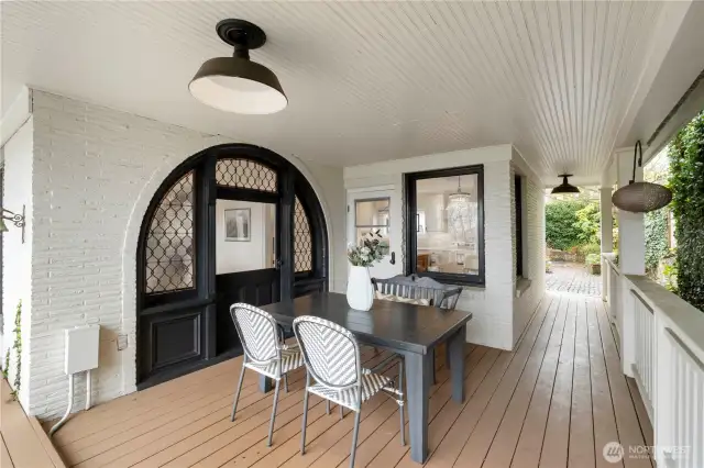 This view of the outdoor covered dining area shows another access point to the secret garden courtyard with brick patio. One of so many beautiful outdoor spaces to enjoy