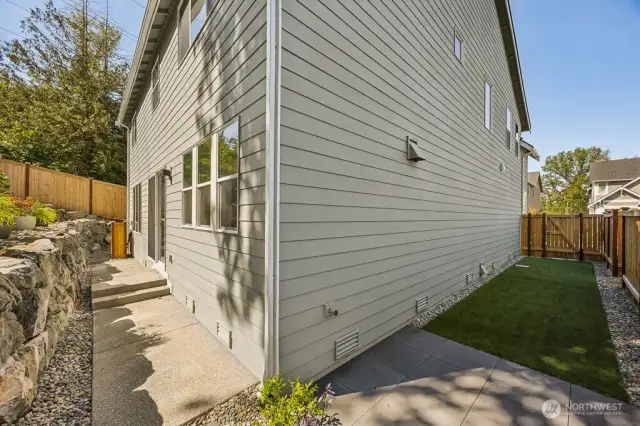 Artificial grass on this side, real grass on the other side of the home that ties in with the front landscaping.