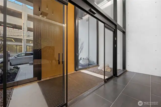 Welcome home through these exquisite doors, where glass, rich wood, and sleek metal seamlessly fuse to create a grand entrance of timeless elegance and modern sophistication.