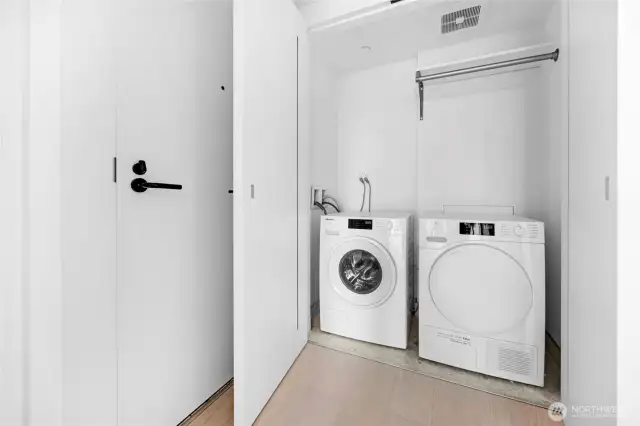 Washer dryer unit behind heavy and ventilated doors