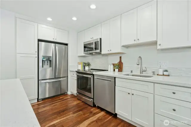 Timeless white shaker island kitchen with full-sized pantry and stainless appliances
