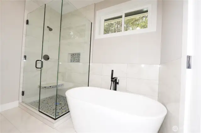 The primary bath has a soaking tub with glass enclosed shower.