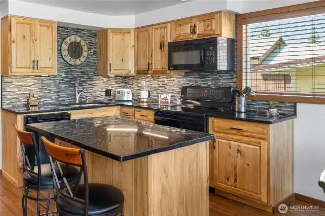 Gorgeous ceramic tile backsplash complements the granite countertops beautifully.