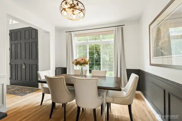Formal dining room with wainscoting and contemporary iron chandelier.