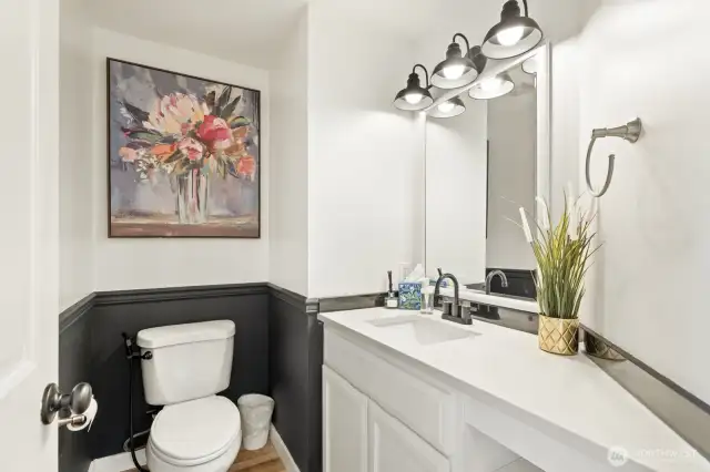 Updated powder bath with quartz vanity and new lighting.