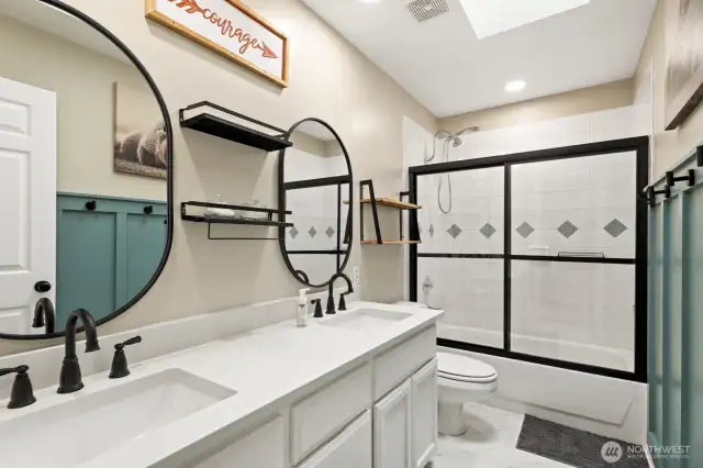Updated hall bath with quartz vanity with 2 under mount sinks.