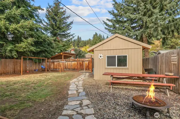 Large back  with fire pit and walk way to 1 car garage or large shed