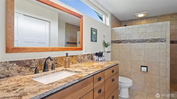 Natural stone slab counters, custom vanity cabinets and heated tile floors envelop you in the natural feel and coziness of the room.