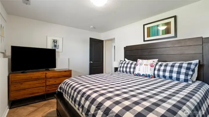 The lower floor has another large bedroom (shown with king bed) which features a large double closet. A nicely remodeled 3/4 bath is directly across the hall.