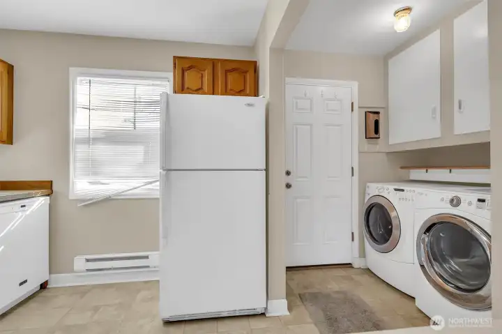 Spacious utility room with full-size washer and dryer.