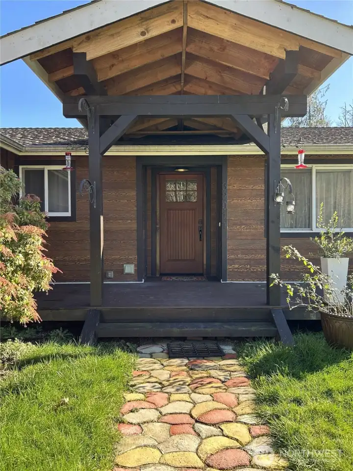 Covered portico and front deck makes for a graceful (and dry) entry to the home.