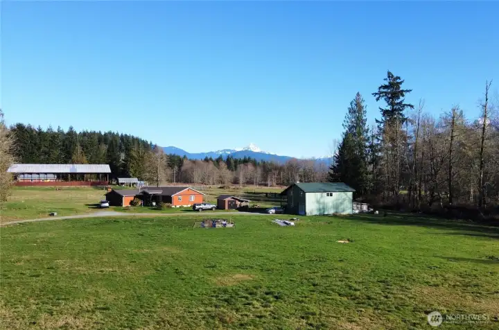 Aerial view of house and outbuildings, looking east.  Equestrian arena in background is located on neighbor's property.