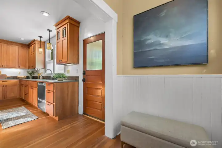 The door leads to the zero entry rear mudroom/entry of the parking area; to the right is pantry space and access to the basement which offers abundant storage The door leads to the zero entry rear mudroom/entry of the parking area; to the right is pantry space and access to the basement which offers abundant storage