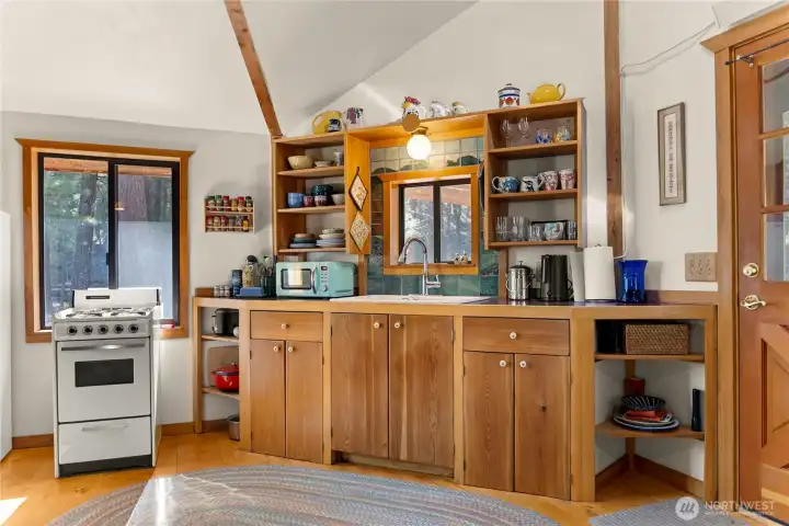 The open kitchen has custom tile work and lots of built-in cabinetry.