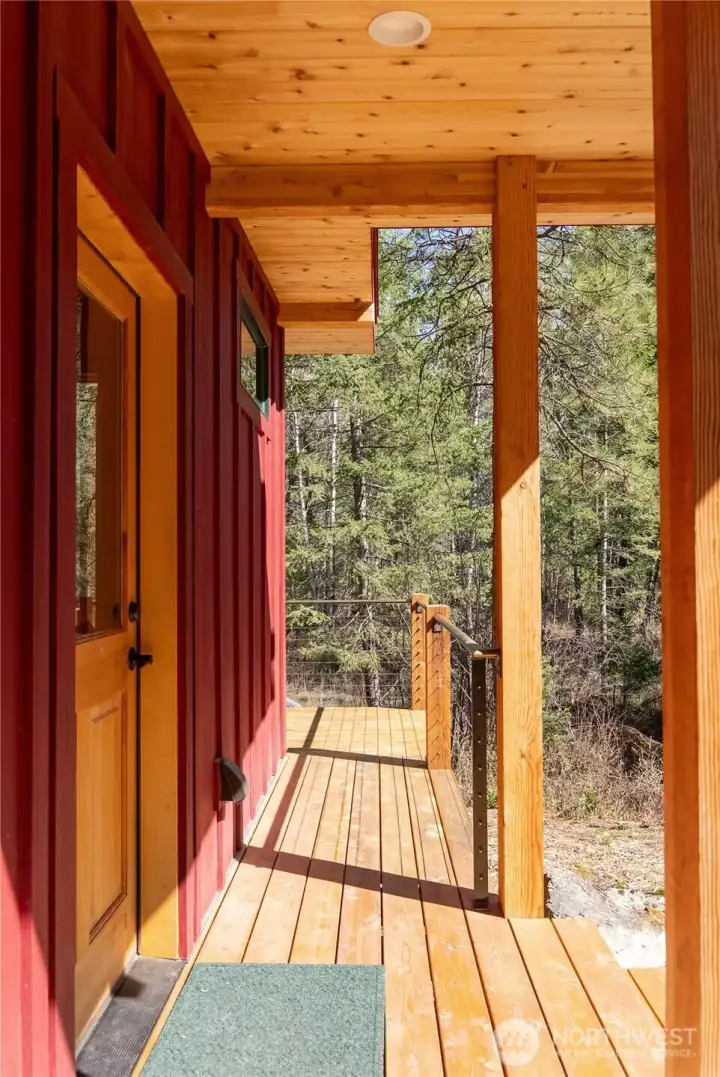 It has a covered entry and wrap-around covered deck from which to admire the forested property.