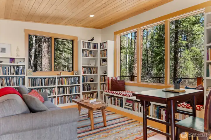 The well-lit studio offers an intimate view of the forested landscape.