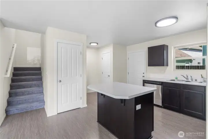 The door to the right of the staircase is storage space! Pantry is shown in background of the island.
