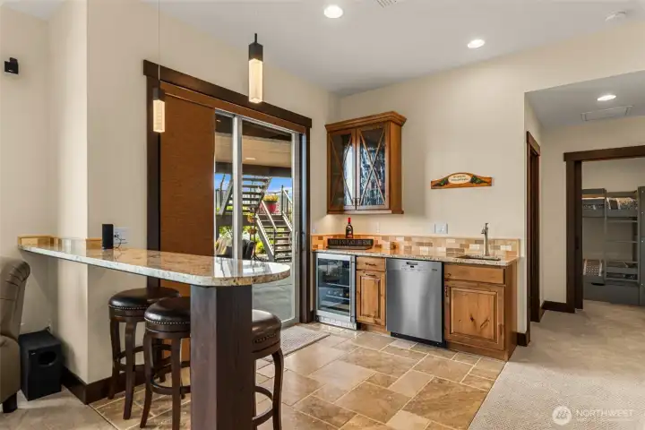 Wet bar with granite, sink, Miele dishwasher and wine fridge.