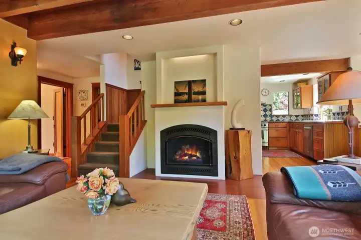 Propane fireplace with live edge Fir mantel. Perfect spot to cozy up and also enough space to entertain. 3/4 Bath is to the left of the stairs. Opened folding cedar & fir doors is the entry to the Primary Suite, Fam Room, Office & Laundry. Propane fireplace with live edge Fir mantel. Perfect spot to cozy up and also enough space to entertain. 3/4 Bath is to the left of the stairs. Opened folding cedar & fir doors is the entry to the Primary Suite, Fam Room, Office & Laundry.