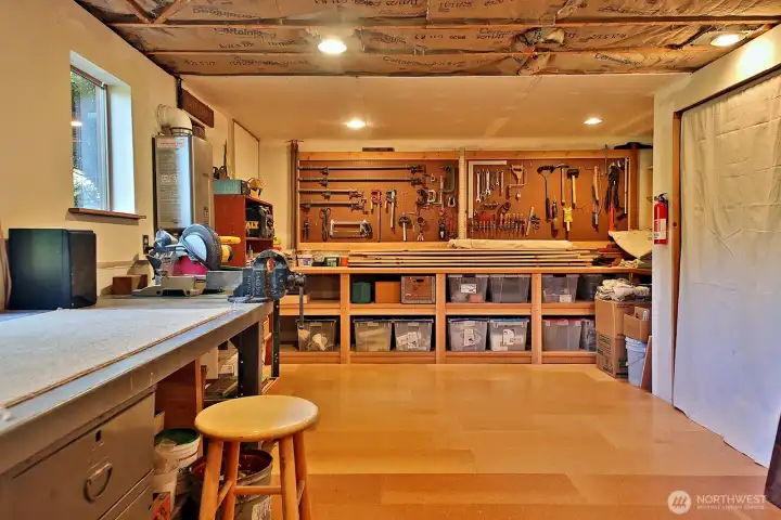Workshop with cork floors. Behind the curtain along the right edge of the photo is where the furnace & one of the hot water heaters live. The ceiling has been fully sheet rocked since this photo was taken. Workshop with cork floors. Behind the curtain along the right edge of the photo is where the furnace & one of the hot water heaters live. The ceiling has been fully sheet rocked since this photo was taken.