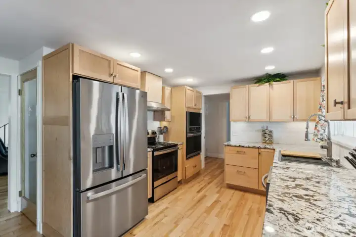 Large open kitchen, with wood floor, granite, deep stainless sink, soft close & 2 walk in pantries