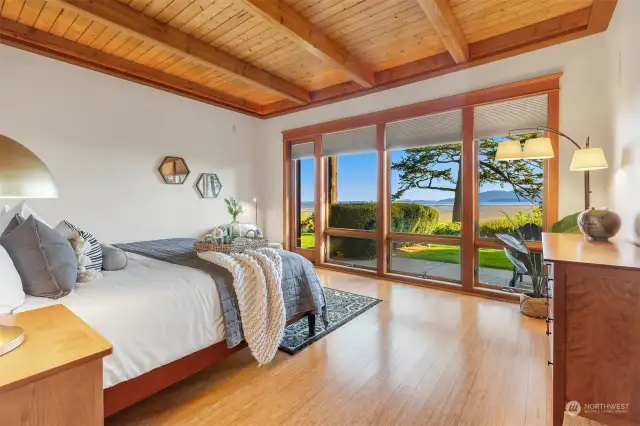 The main floor Primary Suite naturally faces the view.  Bamboo floors, Douglas Fir ceiling beams and window trim accent the space.