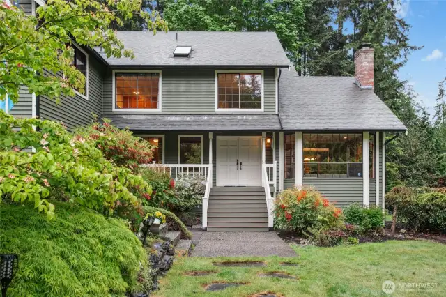Beautiful landscaping leads you up to a sweet covered porch. Quite a welcoming entrance.