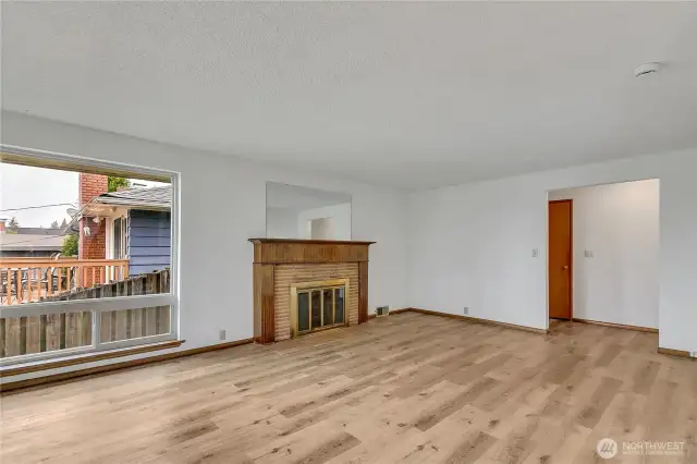 Large windows and wood burning fireplace in living room.