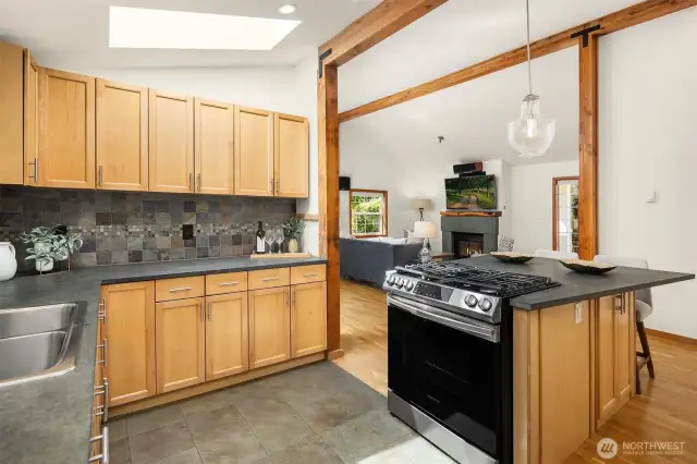 Bright open kitchen with newer stainless steel appliances and limestone slab countertops