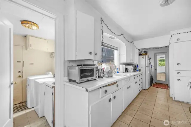Back porch shared laundry area and kitchen.  Good cupboard space for shared housing. Easy care flooring.