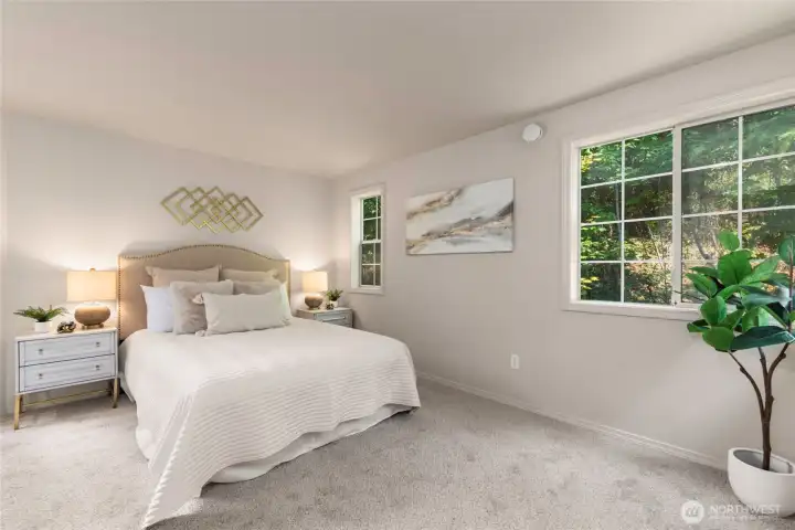 Upstairs primary suite with serene views of green and trees.