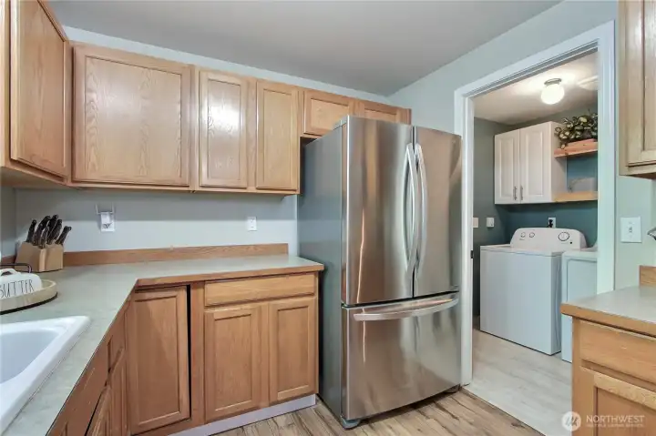 Kitchen view two, utility room off to your right with cabinet and storage, leads to your attached garage for a short grocery commute to your kitchen!