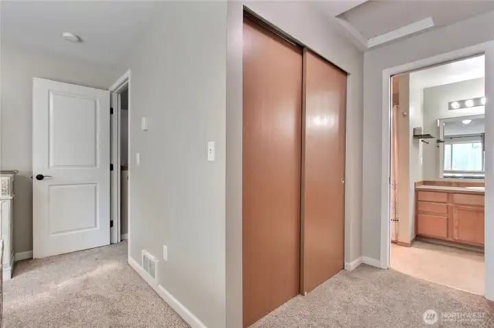 Primary suite view two showing his and hers closets and ensuite bath.