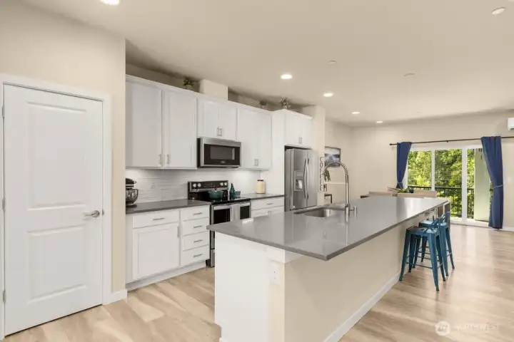 Oversized kitchen island comfortably seats 6. Roomy walk-in pantry to the left.