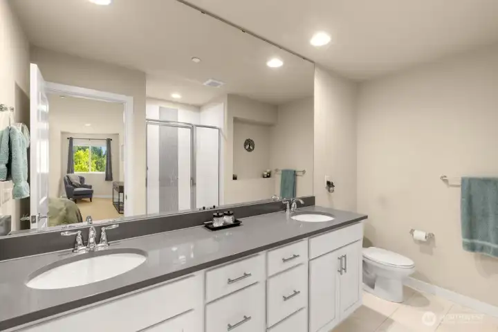 Dual vanity sinks and beautiful tiled shower with high-end finishes throughout.
