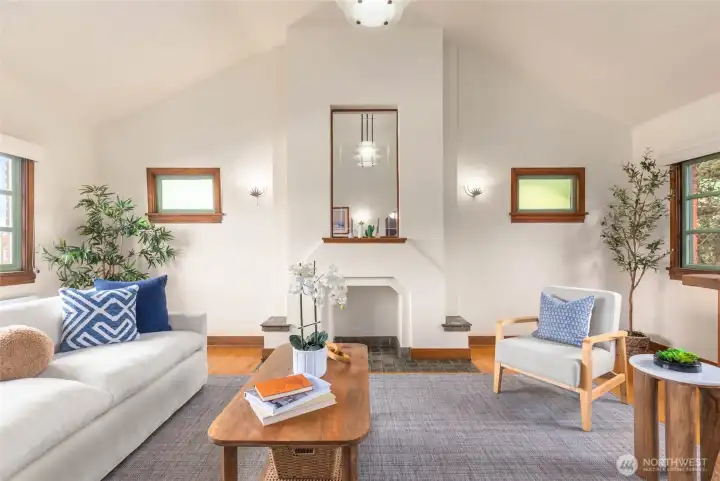Living room with vaulted ceilings and three walls of windows.