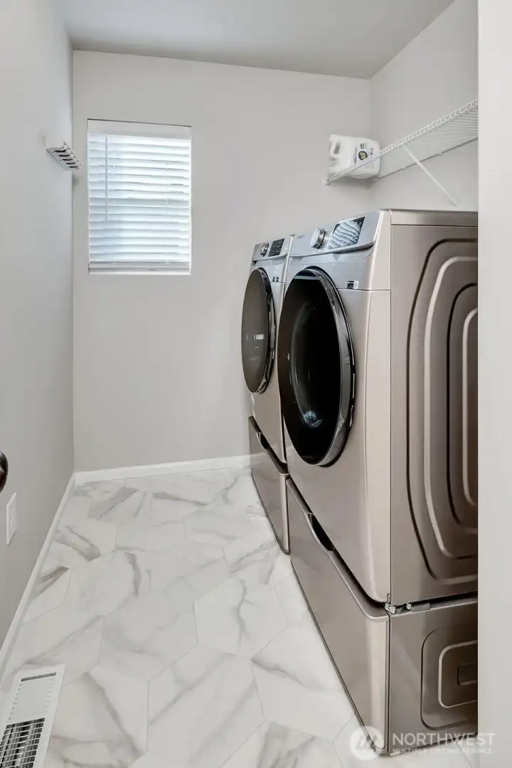 Second floor utility room with newer front loading washer and dryer.