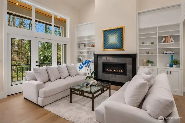 From the moment you step inside, you are met by soaring ceilings, expansive windows, and a stunning connection to the outdoors—your eye is drawn immediately to the natural setting beyond, giving the home a sense of calm, light, and openness that is hard to replicate.