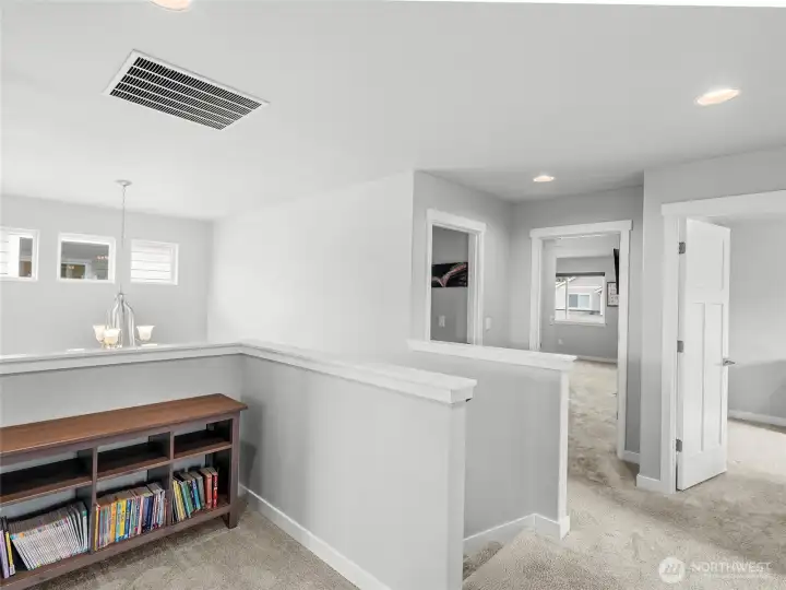 The upstairs landing offers a thoughtfully designed open hallway with views down to the main floor, recessed lighting, and direct access to all upper-level bedrooms. A bright, airy space that connects the home beautifully. This landing offers room for a desk or? Use your imagination here.