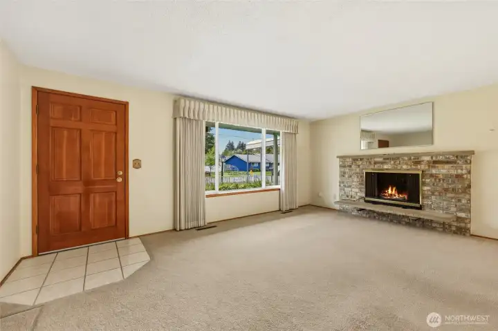Entryway with wood fireplace with brick surround.