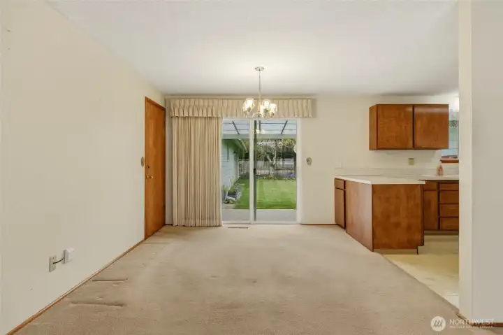 Dining area open to kitchen and living room with slider to covered patio.